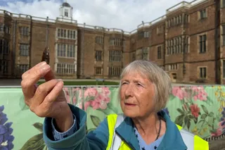 older woman in a high vis jacket holding an arrowhead 