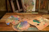old and used art pallets full of paint 
