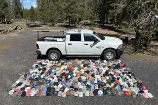 rows and rows of hats lost in Yellowstone national park next to a park truck 