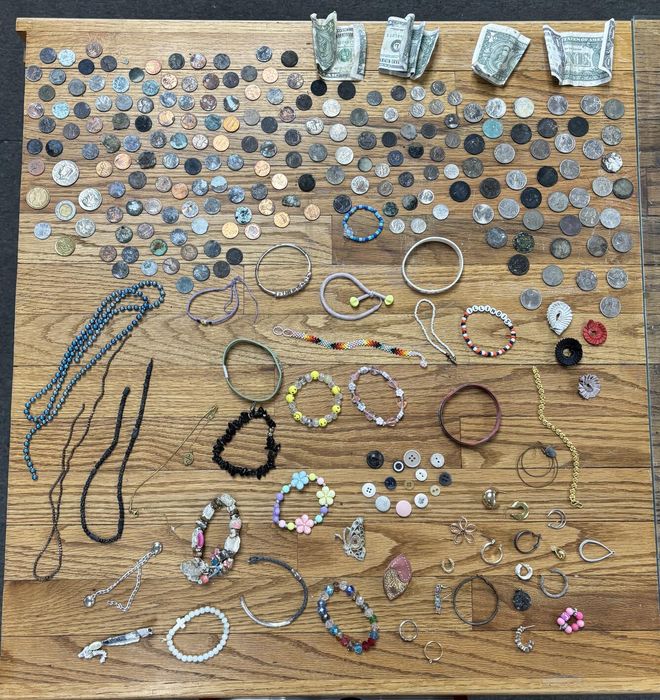 Coins, bills, and jewelry on a table Coins, bills, and jewelry on a table