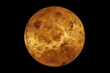 Full globe of Venus in gold and orange tones, showing textured surface features against a black background.