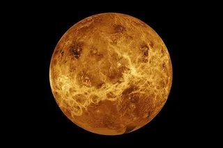 Full globe of Venus in gold and orange tones, showing textured surface features against a black background.