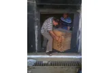 two men lifting wooden box out of a museum 