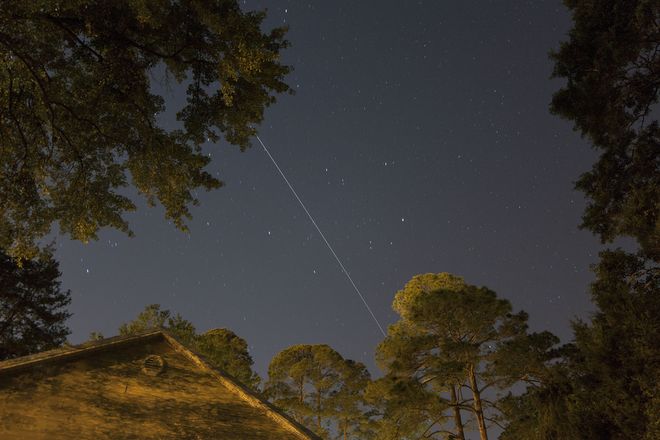 white streak of the ISS flying by the night sky white streak of the ISS flying by the night sky