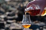 person pours whiskey t