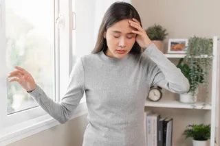 woman holding her head feeling dizzy