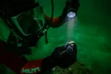 diver holding a bronze ring underwater 