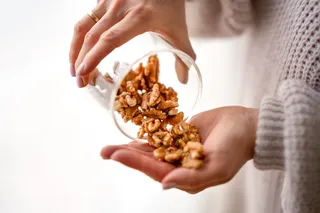Person pouring walnuts into their hand