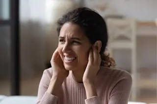 woman plugging her ears